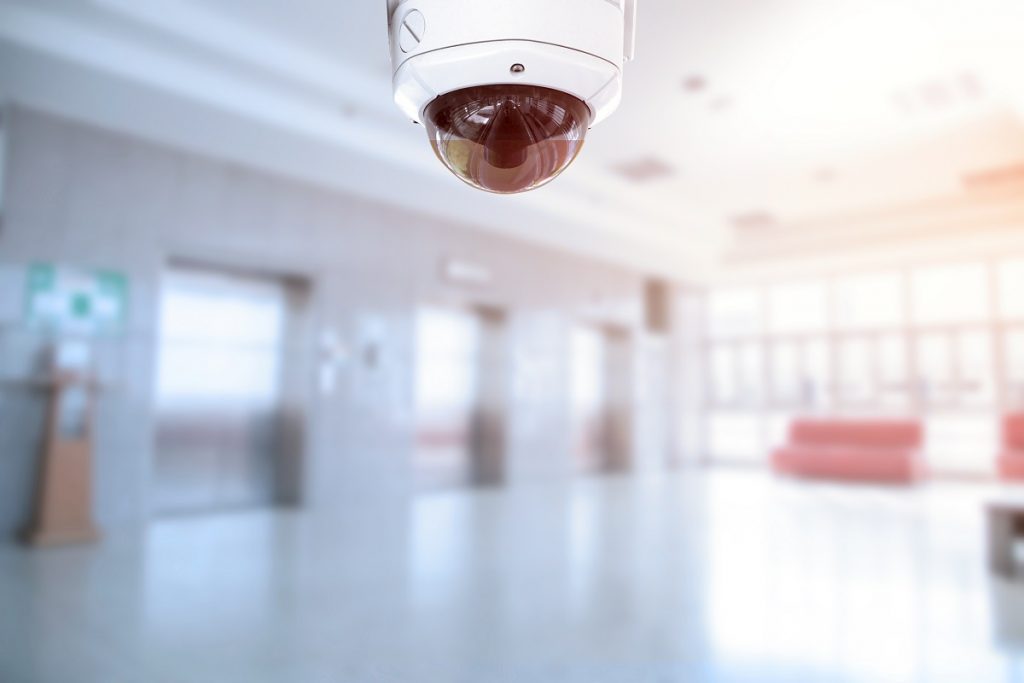 CCTV security camera with office building elevator doors in modern building.